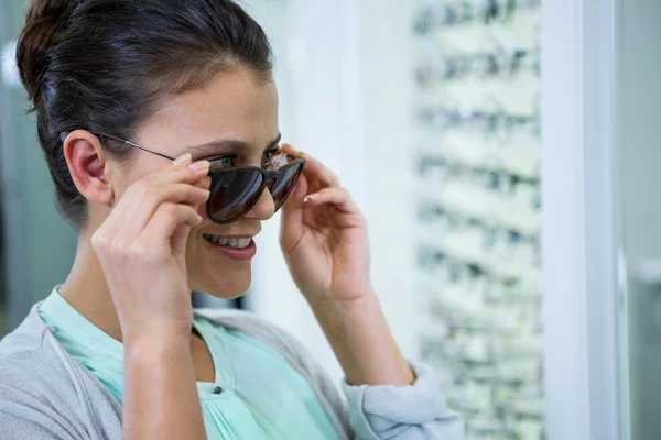 Sorridente cliente femminile cercando occhiali — Foto Stock