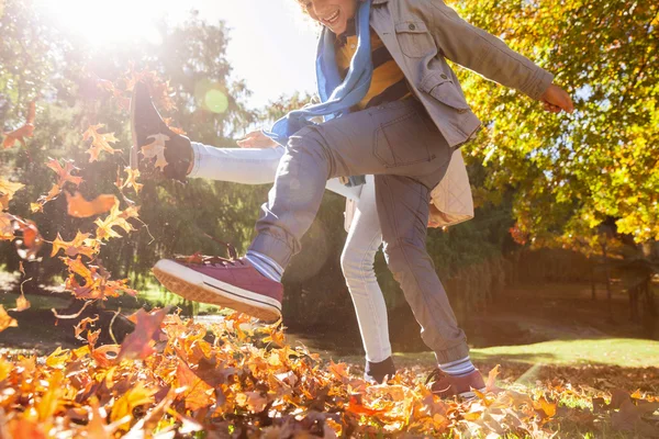 Přátel, kopání podzimní listí — Stock fotografie
