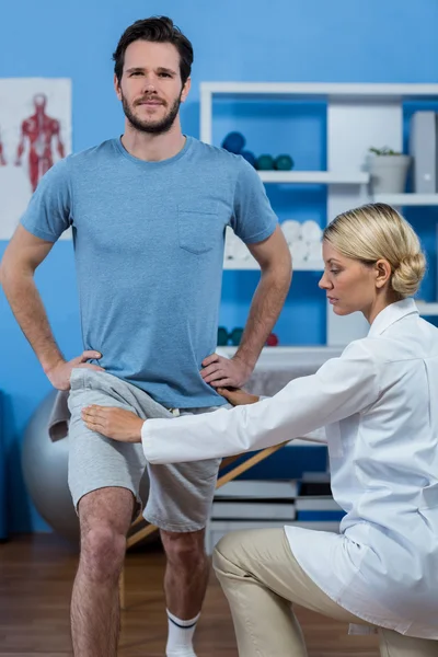 Fysiotherapeut meewerkende patiënt tijdens het sporten — Stockfoto