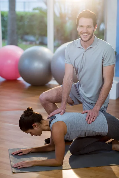 Physiotherapist assisting patient while exercising — Stock Photo, Image