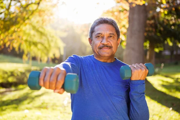 Man exercising with dumbbell at park — Stock Photo, Image