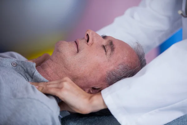 Starší muž přijímá rameno masáže od fyzioterapeuta — Stock fotografie