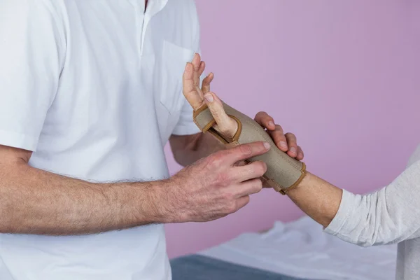 Physiotherapeut untersucht ein älteres Frauenhandgelenk — Stockfoto