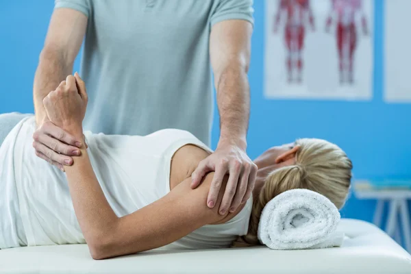 Fisioterapeuta dando massagem no braço ao paciente — Fotografia de Stock