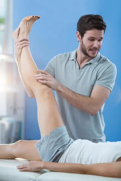 Fisioterapeuta dando massagem no joelho ao paciente — Fotografia de Stock