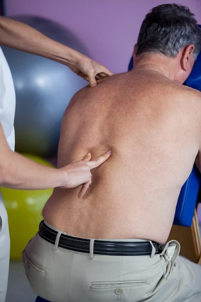 Fisioterapeuta dando masaje de espalda a un paciente — Foto de Stock