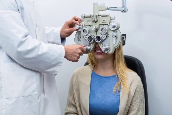 Optometrist examencommissie vrouwelijke patiënt op phoropter — Stockfoto