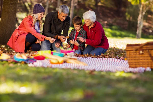 Familjen håller höstlöv på park — Stockfoto