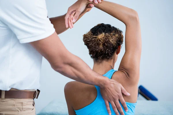 Fisioterapeuta que da terapia de hombro a una mujer — Foto de Stock