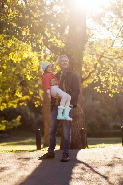 Padre llevando hija por árbol de otoño — Foto de Stock