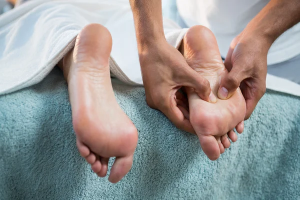 Sjukgymnasten ger fotmassage med en kvinna — Stockfoto