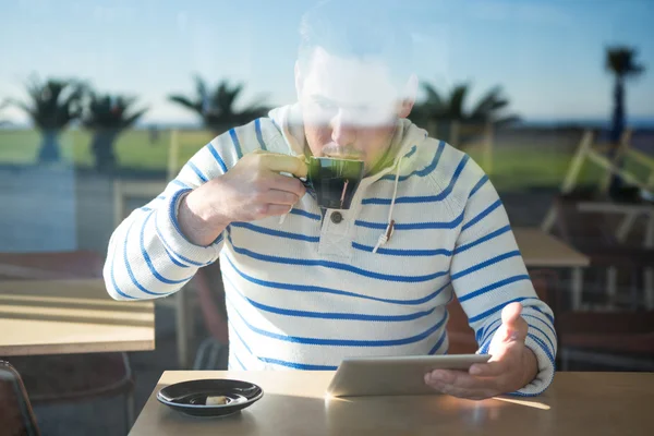 Людина використовує цифровий планшет, маючи каву — стокове фото