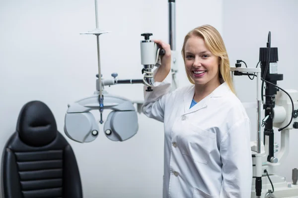 Leende kvinna optiker står nära foropter — Stockfoto