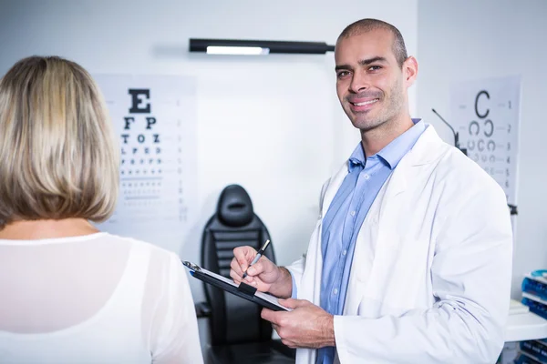 Optometrista masculino que toma la prueba ocular del paciente femenino —  Fotos de Stock