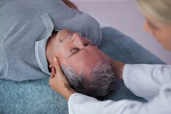 Hombre mayor recibiendo masaje en el cuello de fisioterapeuta — Foto de Stock