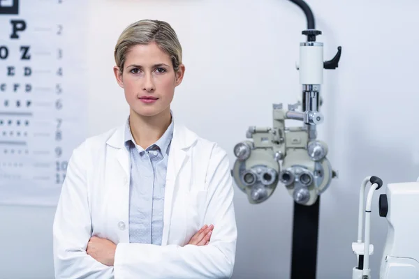 Женщина-оптик, стоящая в офтальмологической клинике — стоковое фото