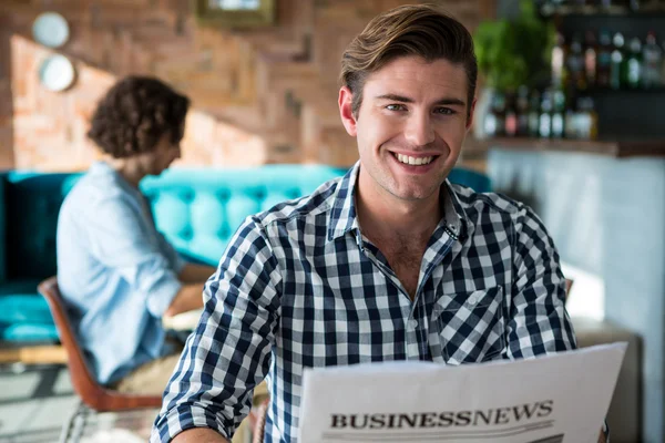 Retrato del hombre sonriente leyendo un periódico de negocios — Foto de Stock