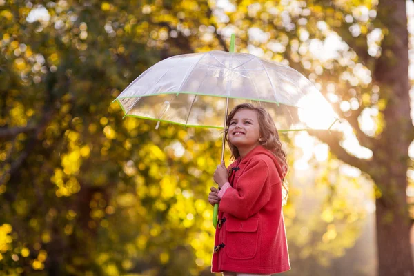 Девушка держит зонтик против деревьев — стоковое фото