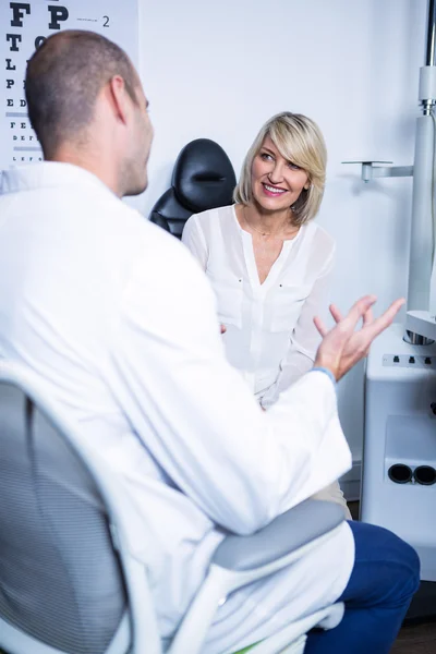 Mannelijke optometrist praten met vrouwelijke patiënt — Stockfoto