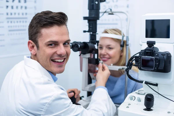 Mosolyogva optometrista női beteg a réslámpa vizsgálata — Stock Fotó