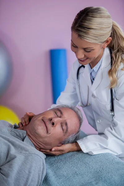 Senior man receiving neck massage from physiotherapist — Stock Photo, Image