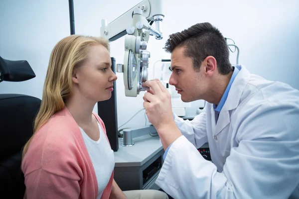 Optometrista examinando paciente femenina en foropter —  Fotos de Stock