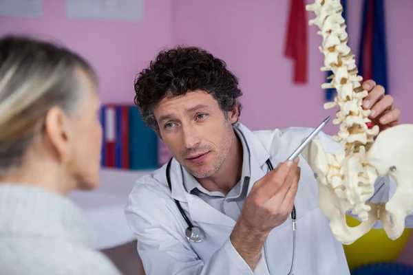 Physiothérapeute expliquant le modèle de colonne vertébrale au patient — Photo