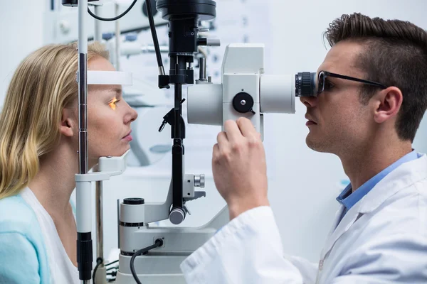 Augenärztin untersucht Patientin an Spaltlampe — Stockfoto