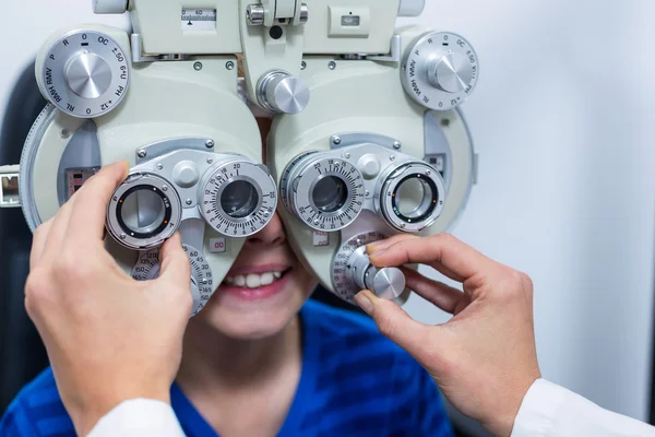 Giovane paziente sottoposto a esame oculare attraverso phoropter — Foto Stock