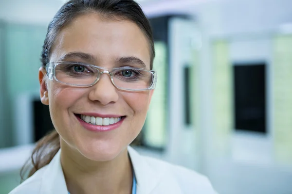 Optometrista en gafas sonriendo en tienda óptica —  Fotos de Stock