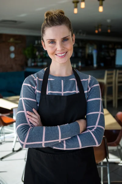 Portrait de serveuse souriante debout les bras croisés — Photo