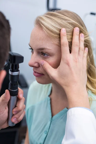 Optometrista examinando paciente femenina a través del oftalmoscopio — Foto de Stock