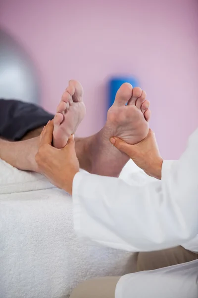 Senior man voetmassage ontvangen fysiotherapeut — Stockfoto