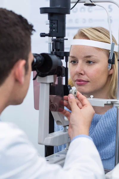 Optometrista examinando paciente femenino en lámpara de hendidura — Foto de Stock