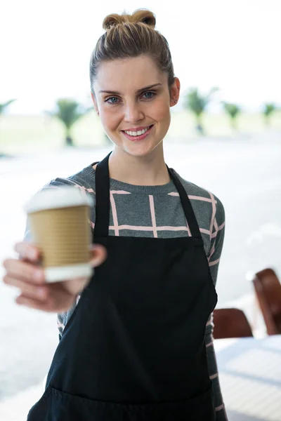 Portret van lachende serveerster aanbieden van koffie — Stockfoto