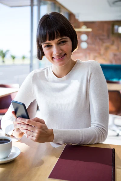Frau benutzt Handy in Cafeteria — Stockfoto