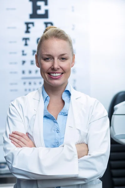 Vrouwelijke optometrist glimlachend in oogheelkunde kliniek — Stockfoto