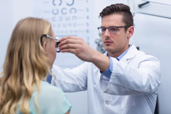 Optometrista examinando paciente femenina con foropter — Foto de Stock