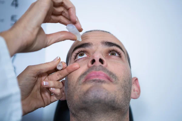 Optometrista poniendo gotas en los ojos de los pacientes — Foto de Stock
