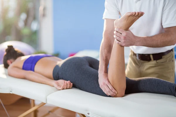 Fisioterapeuta dando massagem no joelho ao paciente — Fotografia de Stock