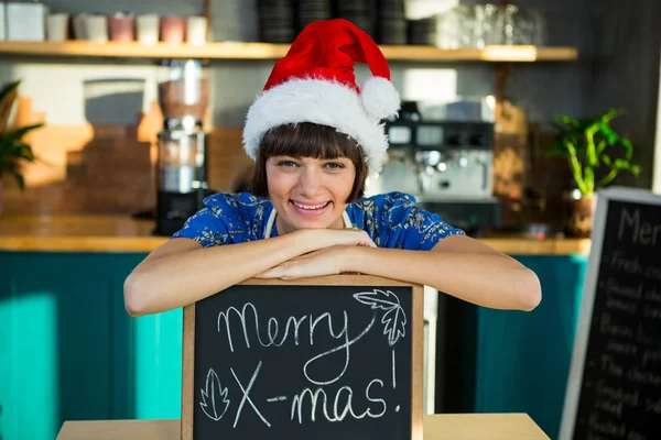 Lächelnde Kellnerin mit Weihnachtsmütze — Stockfoto