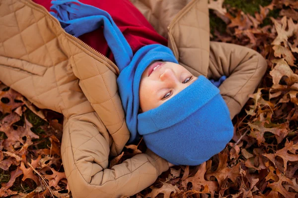 Boy lying at park during autumn — Stock Photo, Image
