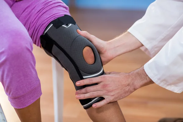 Fisioterapeuta examinando pacientes mujeres rodilla —  Fotos de Stock