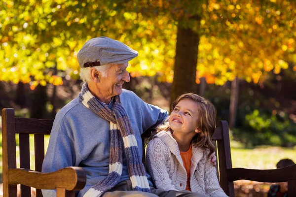 Grand-père assis avec sa petite-fille au parc — Photo