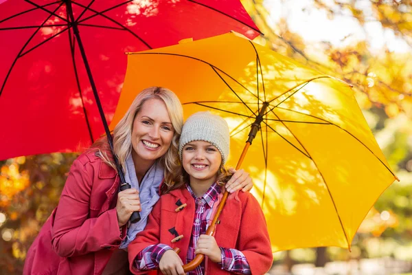 Flicka innehav paraply med mor — Stockfoto