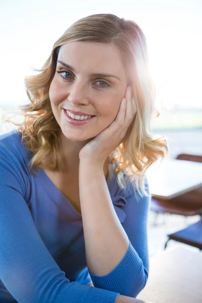 Uśmiechnięta kobieta, siedząc w kawiarni — Zdjęcie stockowe