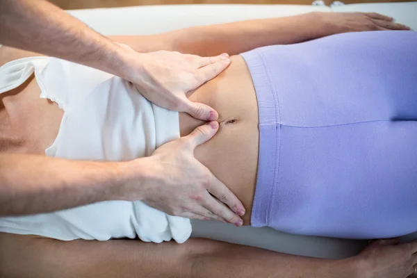 Fisioterapeuta dando massagem estomacal ao paciente — Fotografia de Stock