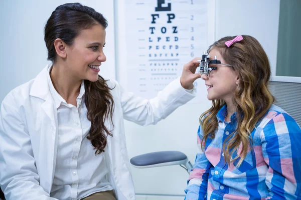 Optometrista femenina examinando paciente joven — Foto de Stock