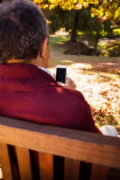 Homme utilisant un téléphone portable tout en se relaxant — Photo