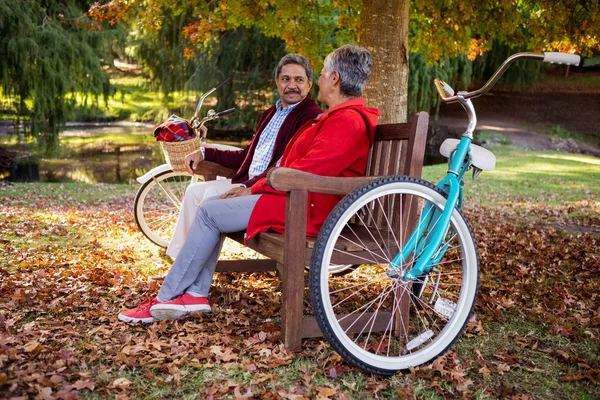 Pareja relajándose en el banco en el parque —  Fotos de Stock